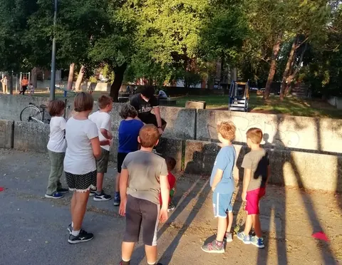 Gruppo di allievi attorno ad un muretto che ascoltano il prossimo esercizio
